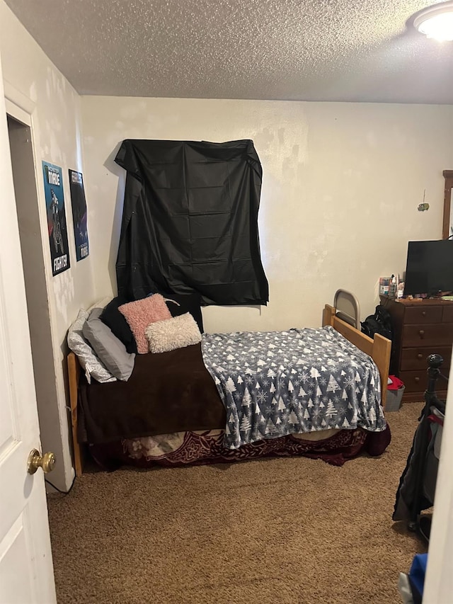 bedroom with carpet and a textured ceiling