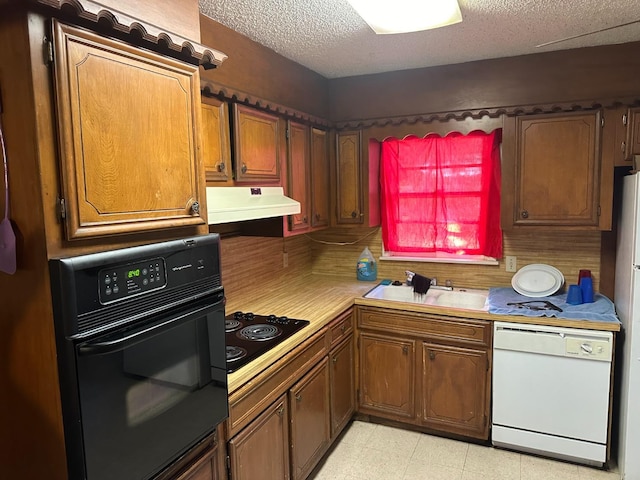 kitchen featuring sink, a textured ceiling, and black appliances