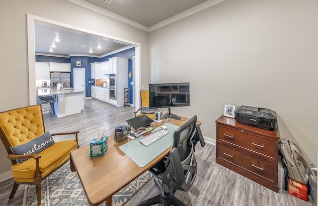 office area featuring ornamental molding, sink, and light wood-type flooring