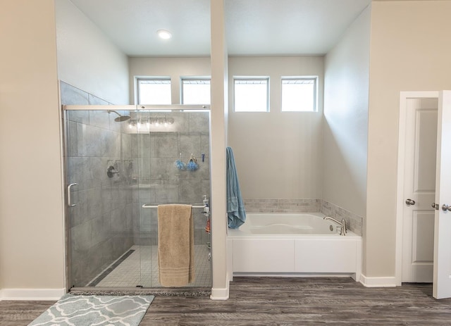 bathroom with plenty of natural light, shower with separate bathtub, and hardwood / wood-style floors