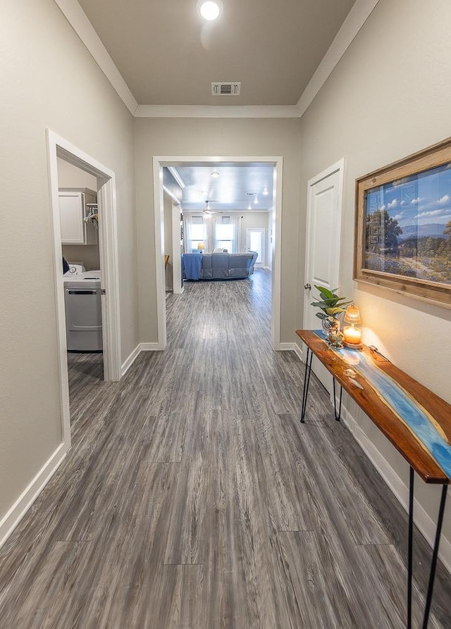 hall featuring ornamental molding, washer / dryer, and dark hardwood / wood-style floors