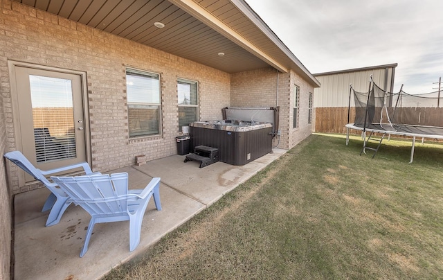 view of patio featuring a hot tub and a trampoline