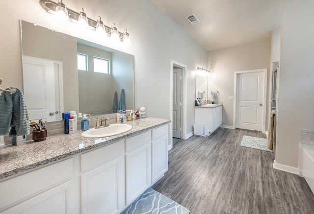 bathroom featuring vanity, a bathtub, and hardwood / wood-style flooring