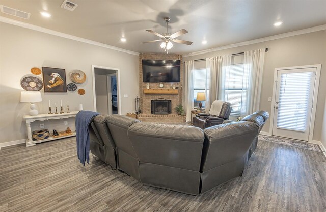 living room featuring ornamental molding, a brick fireplace, wood-type flooring, and ceiling fan