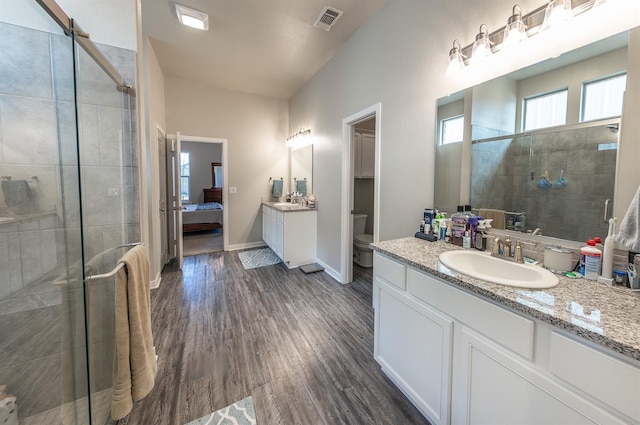 bathroom featuring an enclosed shower, vanity, wood-type flooring, and toilet