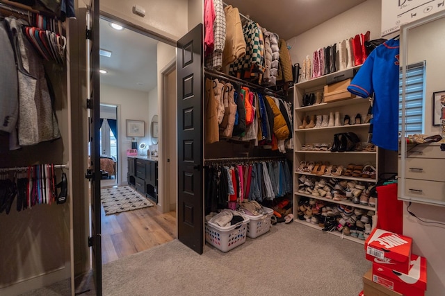walk in closet featuring carpet flooring and wood finished floors