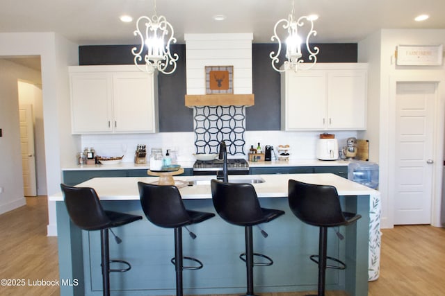 1023 N Fulton Ave, Lubbock, TX 79416 - kitchen featuring a chandelier, decorative backsplash, light wood-type flooring, light countertops, and recessed lighting
