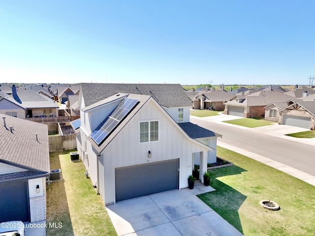 1023 N Fulton Ave, Lubbock, TX 79416 - view of front of home featuring board and batten siding, a residential view, roof with shingles, driveway, and solar panels