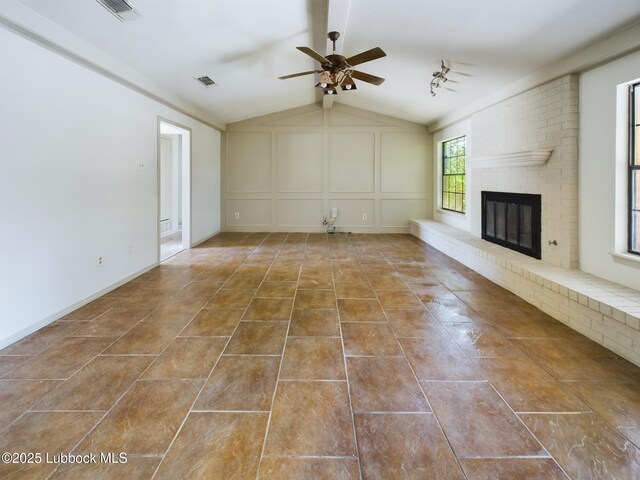 3419 101st St, Lubbock, TX 79423 - unfurnished living room featuring a ceiling fan, lofted ceiling, a fireplace, and a decorative wall