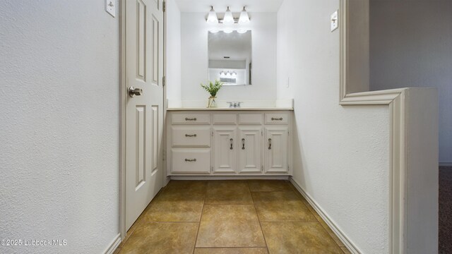 3419 101st St, Lubbock, TX 79423 - bathroom with vanity, a textured wall, and tile patterned flooring