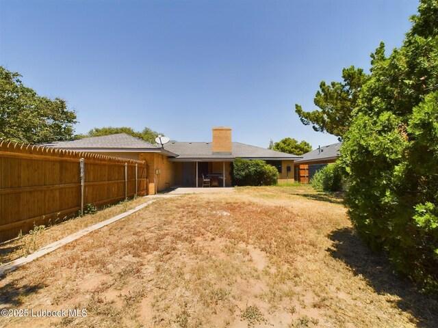 3419 101st St, Lubbock, TX 79423 - rear view of house with a chimney and a patio