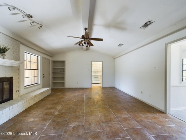 3419 101st St, Lubbock, TX 79423 - unfurnished living room featuring a ceiling fan, dark tile patterned flooring, a brick fireplace, and built in shelves