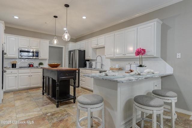 9406 Wayne Ave, Lubbock, TX 79424 - kitchen featuring appliances with stainless steel finishes, tasteful backsplash, a kitchen breakfast bar, white cabinetry, and recessed lighting