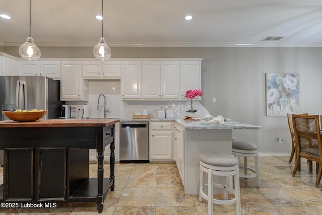 9406 Wayne Ave, Lubbock, TX 79424 - kitchen with appliances with stainless steel finishes, white cabinetry, stone tile floors, recessed lighting, and crown molding