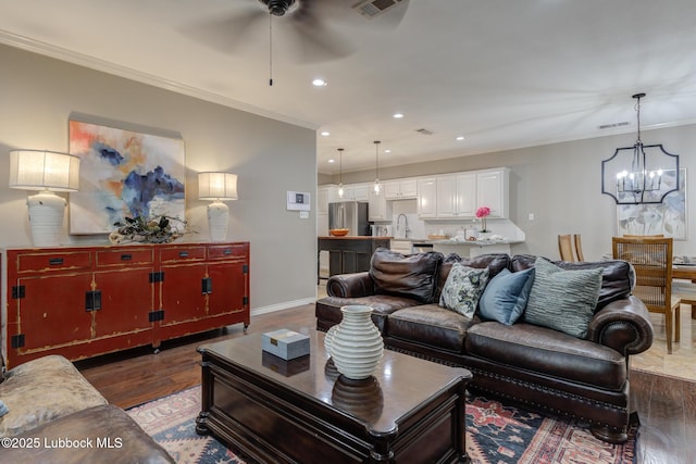 9406 Wayne Ave, Lubbock, TX 79424 - living room featuring a ceiling fan, a chandelier, wood finished floors, recessed lighting, and ornamental molding
