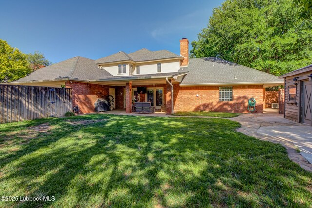 9406 Wayne Ave, Lubbock, TX 79424 - back of property featuring a chimney, a patio area, brick siding, and a shingled roof
