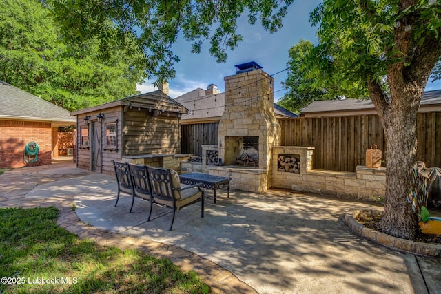 9406 Wayne Ave, Lubbock, TX 79424 - view of patio / terrace featuring an outdoor stone fireplace and an outbuilding