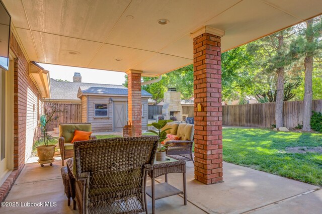9406 Wayne Ave, Lubbock, TX 79424 - view of patio with an outdoor living space with a fireplace and an outbuilding