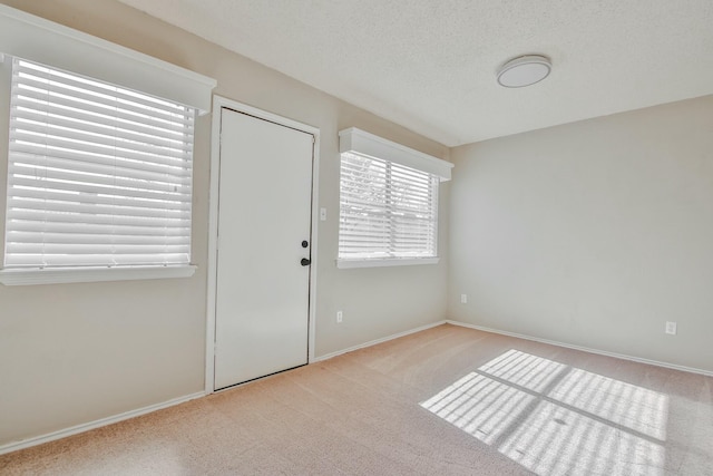 foyer entrance with light carpet and a textured ceiling