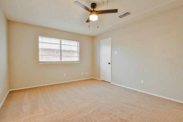 empty room featuring ceiling fan and light colored carpet