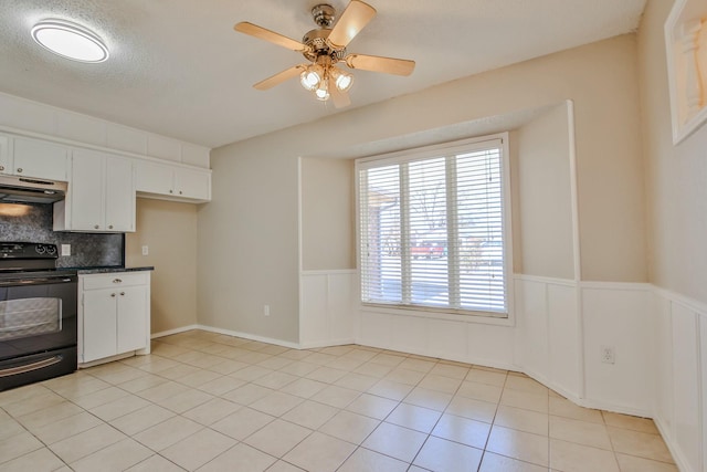 kitchen featuring tasteful backsplash, white cabinetry, light tile patterned floors, electric range, and ceiling fan