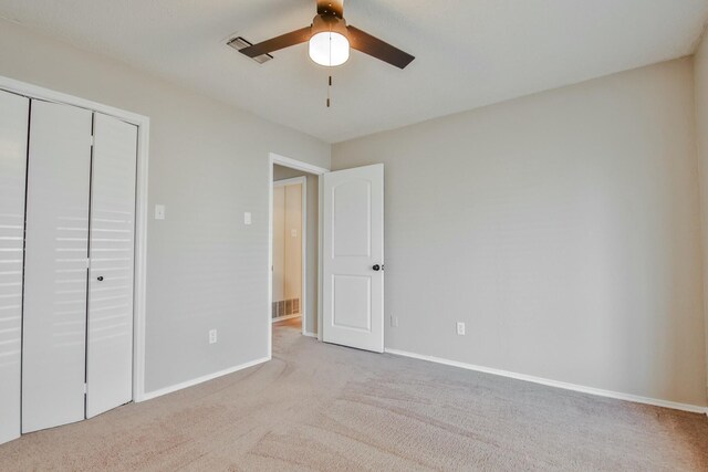 unfurnished bedroom with light colored carpet, ceiling fan, and a closet