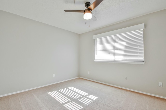 carpeted spare room featuring a textured ceiling and ceiling fan