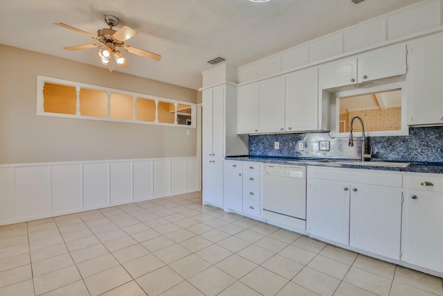 kitchen featuring sink, ceiling fan, white dishwasher, tasteful backsplash, and white cabinets