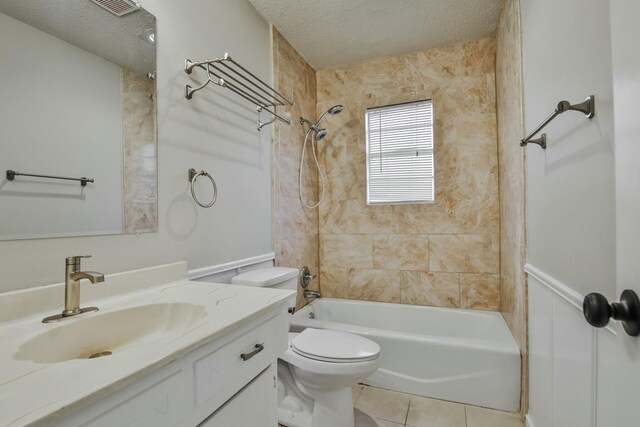 full bathroom with vanity, tiled shower / bath, tile patterned floors, and a textured ceiling