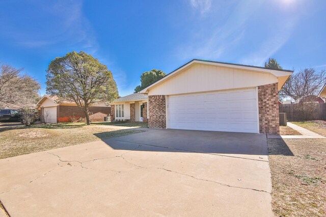 single story home with cooling unit and a garage