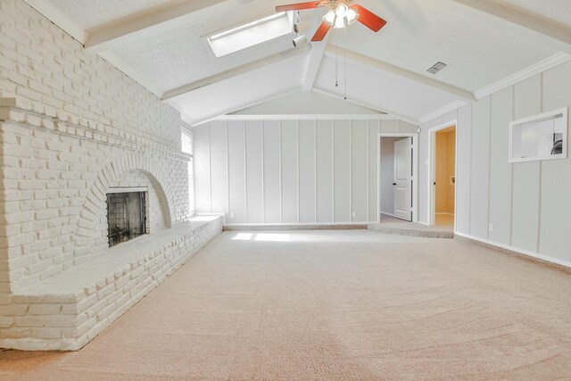 unfurnished living room featuring a brick fireplace, lofted ceiling with beams, ceiling fan, and carpet