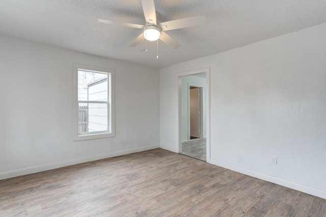 unfurnished room with ceiling fan, a textured ceiling, and light hardwood / wood-style flooring