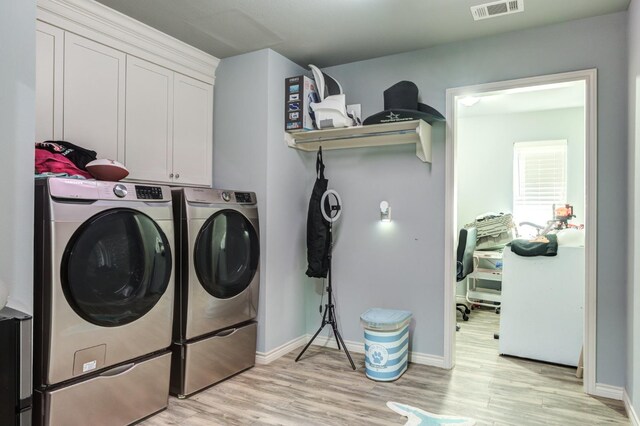 washroom with cabinets, light wood-type flooring, and independent washer and dryer