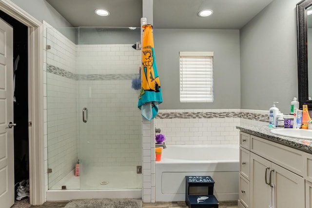 bathroom featuring vanity and independent shower and bath