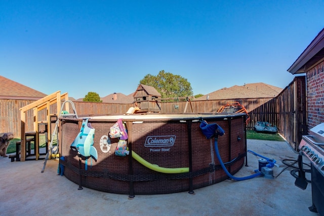 view of property's community featuring a playground, a patio, and a pool