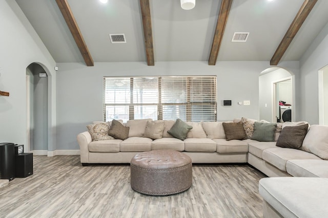 living room featuring washer / dryer, lofted ceiling with beams, and light hardwood / wood-style flooring