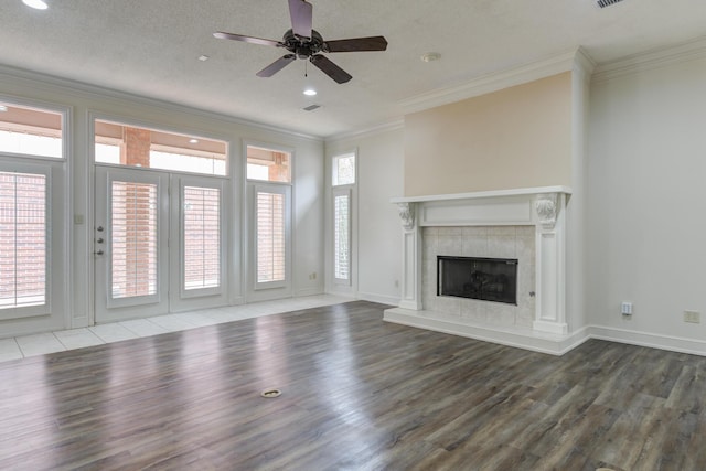 4107 101st St, Lubbock, TX 79423 - unfurnished living room featuring wood finished floors, crown molding, ceiling fan, a tile fireplace, and recessed lighting