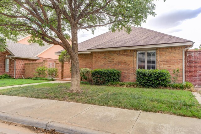4107 101st St, Lubbock, TX 79423 - ranch-style house with a shingled roof, a front lawn, and brick siding