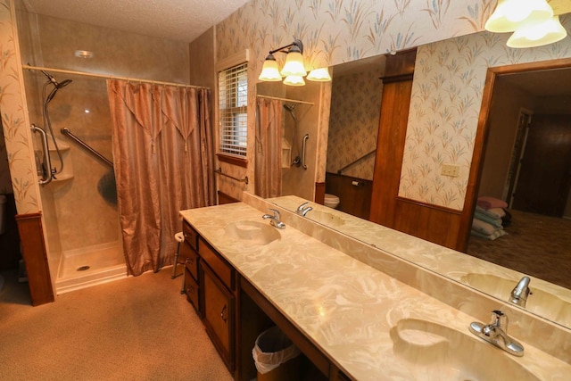 bathroom with vanity, curtained shower, toilet, and a textured ceiling