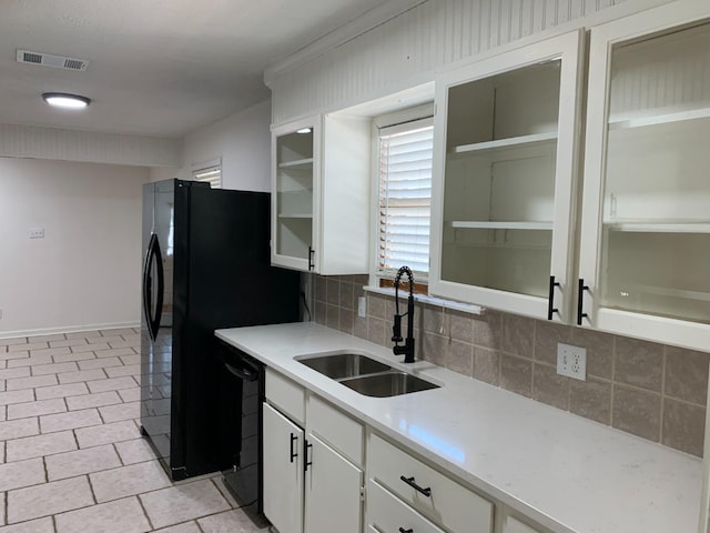 kitchen with white cabinetry, sink, tasteful backsplash, and black appliances