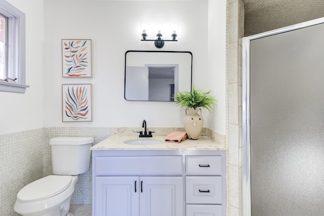 bathroom featuring vanity, toilet, tile walls, and walk in shower