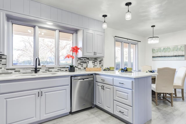 kitchen with sink, decorative light fixtures, stainless steel dishwasher, kitchen peninsula, and backsplash