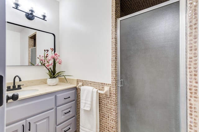 bathroom with a shower with door and vanity