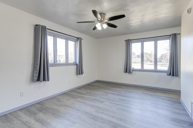 unfurnished room with ceiling fan, plenty of natural light, and light wood-type flooring