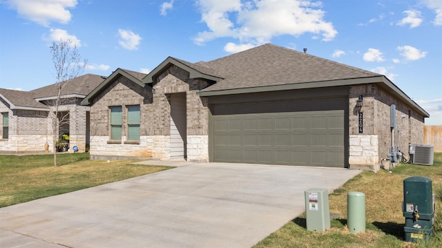 view of front of property with a garage, a front yard, and central air condition unit