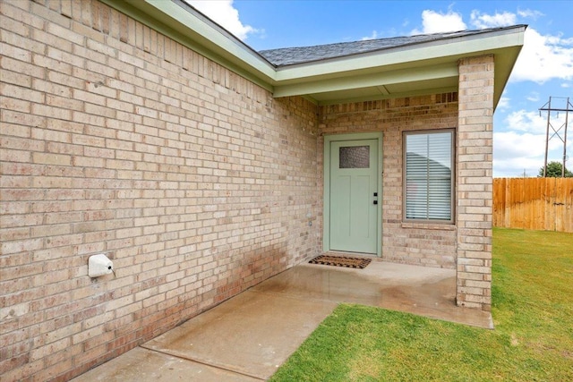 property entrance featuring a patio and a lawn