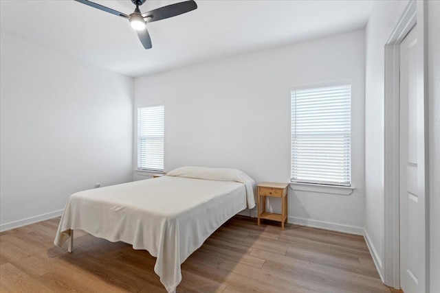 bedroom featuring multiple windows, light hardwood / wood-style flooring, and ceiling fan