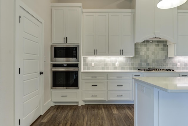 4603 140th St, Lubbock, TX 79424 - kitchen with appliances with stainless steel finishes, light countertops, dark wood finished floors, white cabinetry, and backsplash