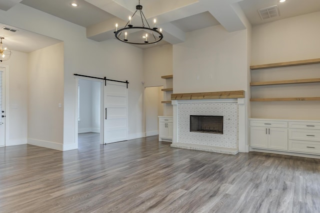 4603 140th St, Lubbock, TX 79424 - unfurnished living room featuring a chandelier, a barn door, wood finished floors, a fireplace, and recessed lighting