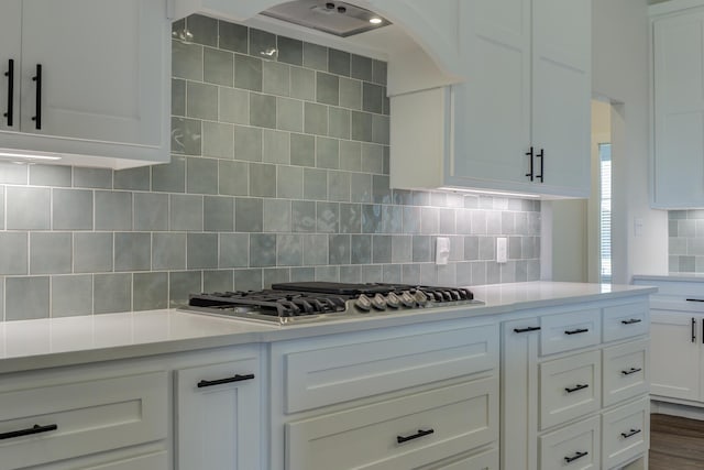 4603 140th St, Lubbock, TX 79424 - kitchen with light countertops, white cabinets, stainless steel gas cooktop, decorative backsplash, and arched walkways